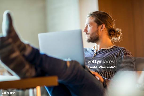 portrait of pensive young man using laptop - business studies stockfoto's en -beelden