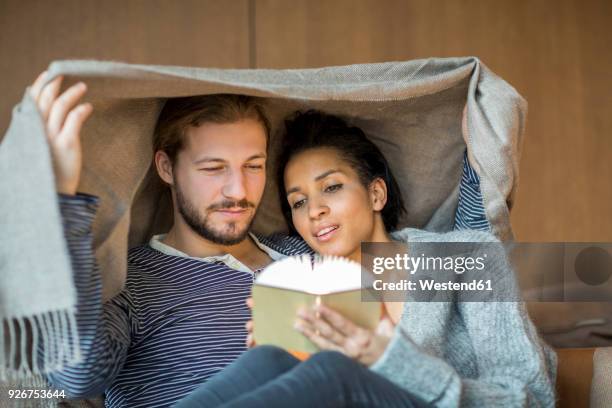 portrait of young couple relaxing together at home - lumière ambiante photos et images de collection
