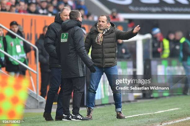 Head coach Manuel Baum and Stefan Reuter of Augsburg argue with the fourth official during the Bundesliga match between FC Augsburg and TSG 1899...