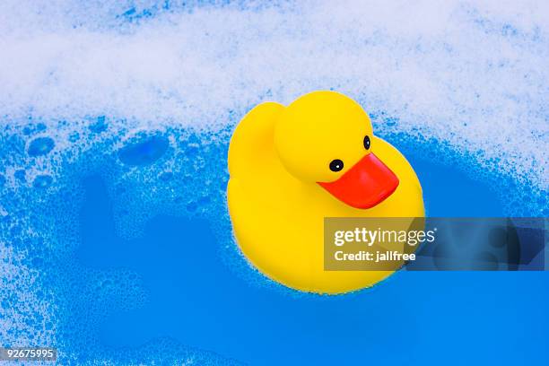amarillo pato de juguete en el baño de agua y azul de burbujas - parpar fotografías e imágenes de stock