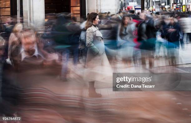 woman in the big city surrounded by blurry pedestrians - streak stock pictures, royalty-free photos & images