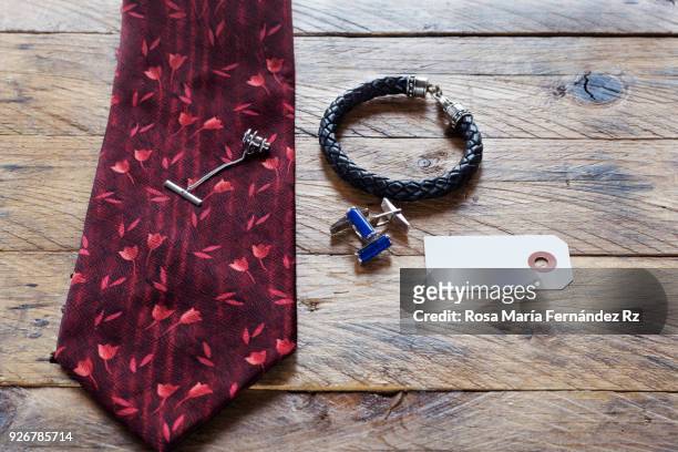 fashion accessories. elegance necktie silver tie pin, cuff link, gentleman's bracelet and blank greeting card on rustic wooden background. selective focus and copy space. father's day concept - cufflink fotografías e imágenes de stock