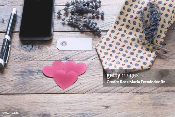 father's day concept. necktie with bouquet of lavender held with silver tie pin, blank greeting card, smart phone, fountain pen, paper hearts shape on rustic wooden background. selective focus and copy space. - tie pin stock-fotos und bilder