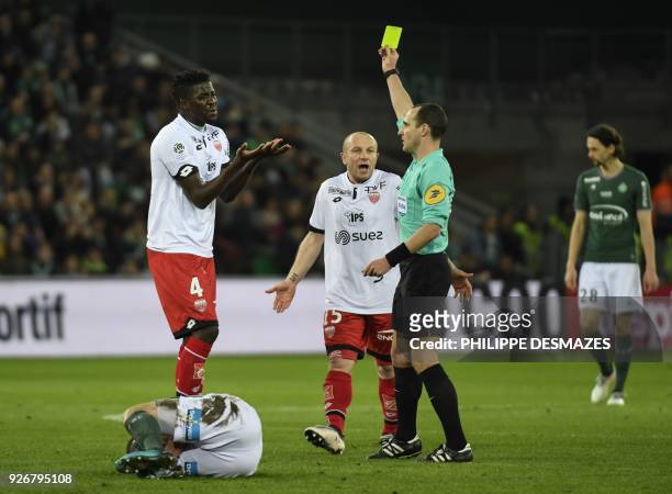 French referee Benoit Millot gives a yellow card to Dijon's Senegalese defender Papy Djilobodji during the French L1 football match between AS...
