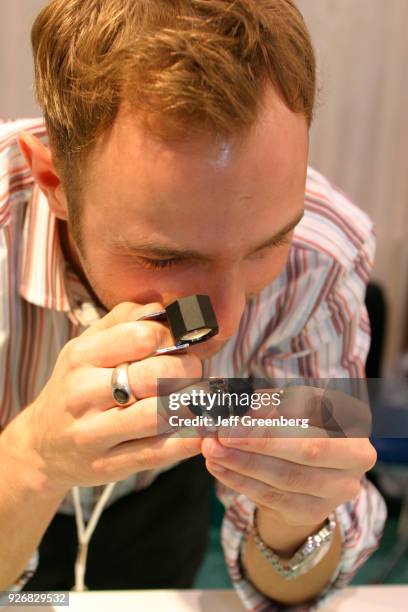 Gemologist examines an Alexandrite ring at an Antique Show.