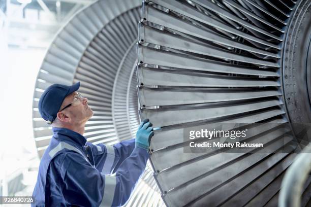 close up of engineer inspecting low pressure turbine during inspection in turbine maintenance factory - manufacturing occupation stock-fotos und bilder