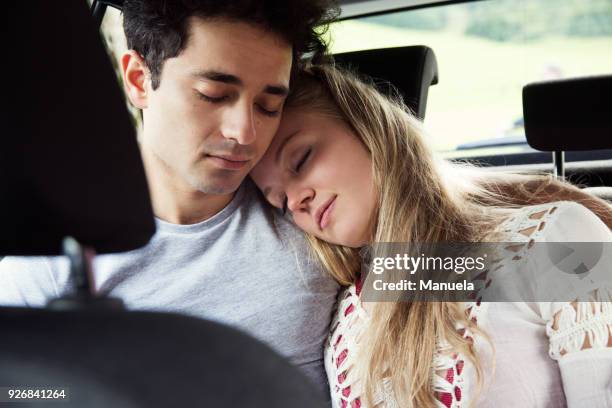 couple in backseat of car sleeping - couple sleeping in car photos et images de collection