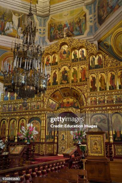 Interior of Ascension Cathedral in Almaty Kazakhstan with gold leaf iconostasis wall to the sanctuary.