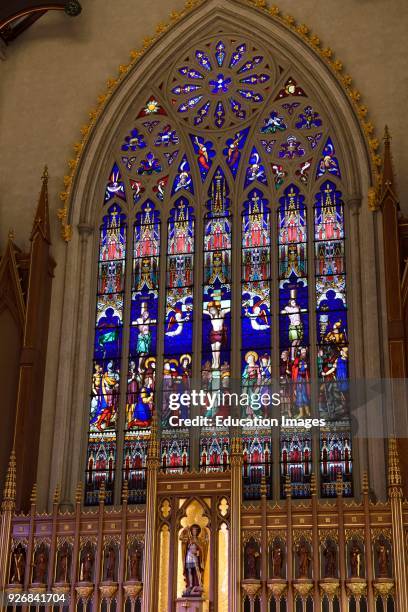 Statues of St Michael and 12 Apostles with Stained glass window of crucifixion in Cathedral Basilica Toronto.