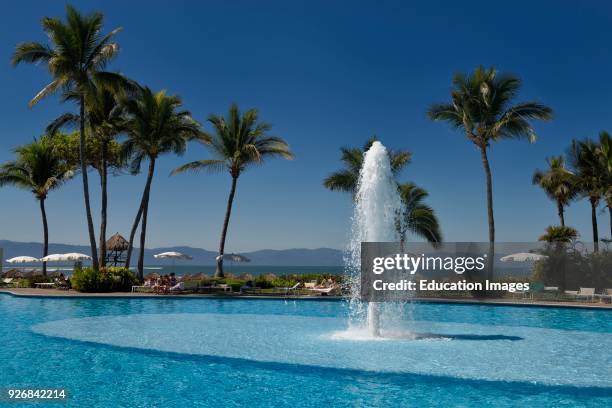 Pool with fountain at Nuevo Vallarta Mexico with Palm trees and vacationers.