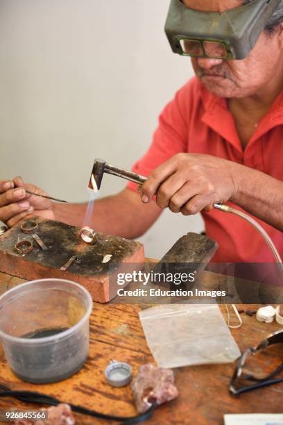 Jeweler working on a gold ring with a welding torch Mexico.