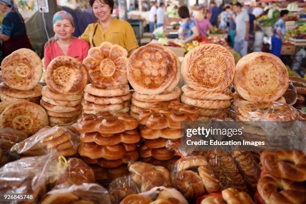 Shop keepers in Shymkent Central Market next to table of Kazakh Tandyr nan breads Kazakhstan.