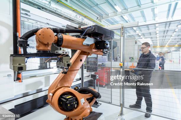 robotics engineer operating robot aided cnc machine in robotics research facility - cnc stock pictures, royalty-free photos & images