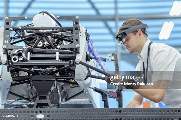 engineer using augmented reality headset to see parts position on car in assembly composite image showing cad drawing of part in robotics research facility - augmented reality car stockfoto's en -beelden