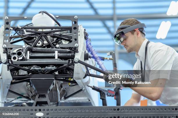 engineer using augmented reality headset to see parts position on car in assembly composite image showing cad drawing of part in robotics research facility - augmented reality stock pictures, royalty-free photos & images