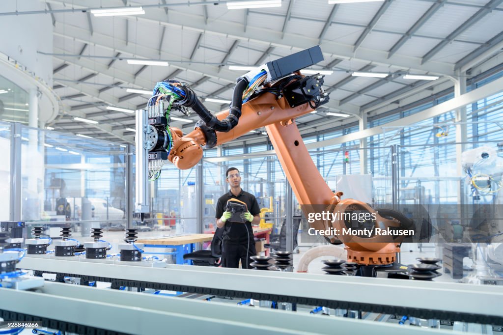 Engineer programming robot in robotics research facility