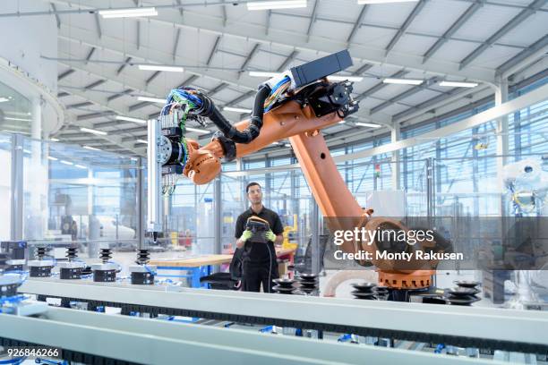 engineer programming robot in robotics research facility - indústria imagens e fotografias de stock