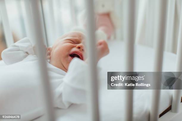 baby girl lying in crib crying - babies only stock pictures, royalty-free photos & images