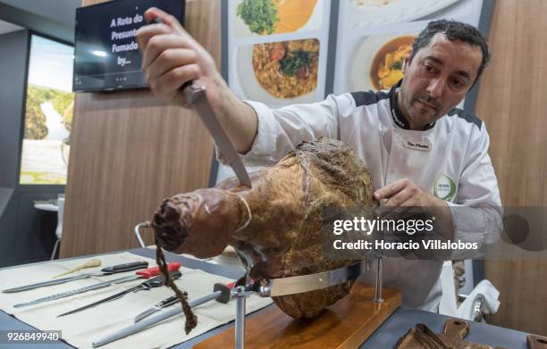 Portuguese Chef Vitor de Oliveira slices into a smoked ham at Porto-Norte stand as part of the presentation of the touristic "Rota do Presunto...