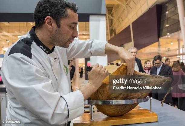 Portuguese Chef Vitor de Oliveira slices into a smoked ham at Porto-Norte stand as part of the presentation of the touristic "Rota do Presunto...