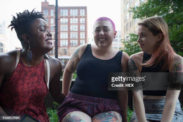 three young women sitting down - big fat white women stock-fotos und bilder