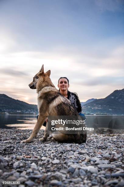 portrait of young woman and dog on riverbank, vercurago, lombardy, italy - vercurago stock pictures, royalty-free photos & images