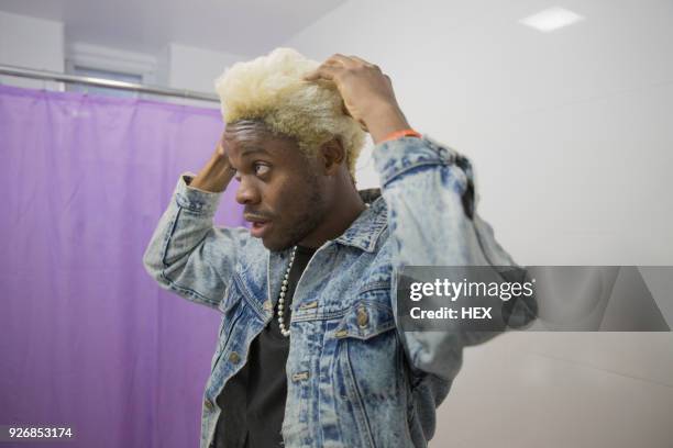 a young man styling his hair - bleached hair stock-fotos und bilder