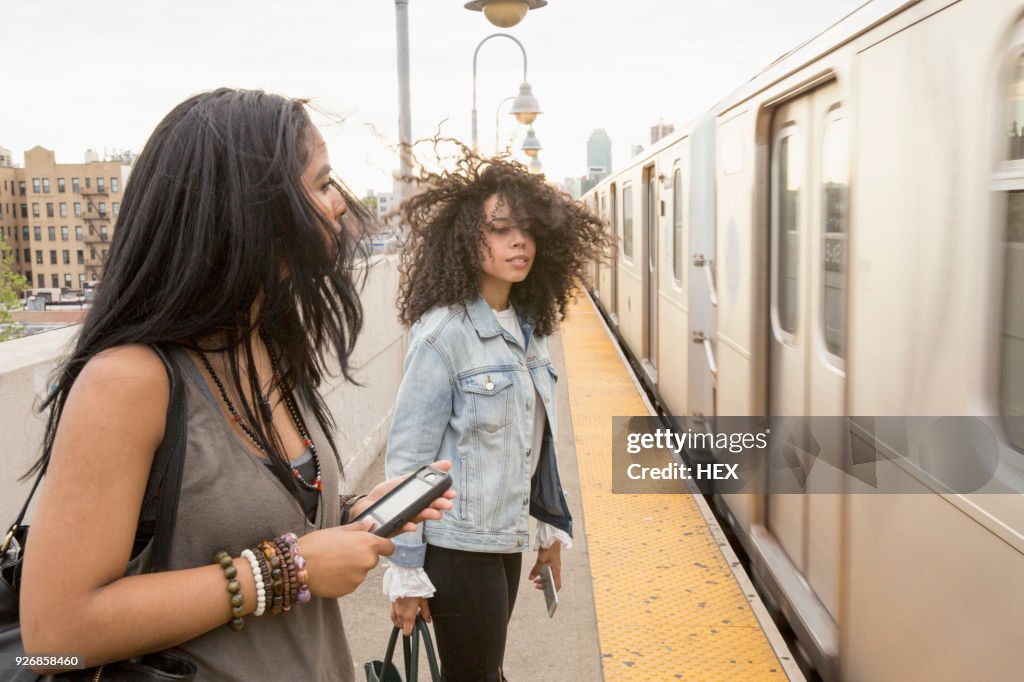 Young women waiting at a train station in Queens, New York