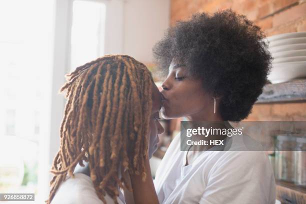 lesbian couple kissing in their kitchen - photos of lesbians kissing stock pictures, royalty-free photos & images