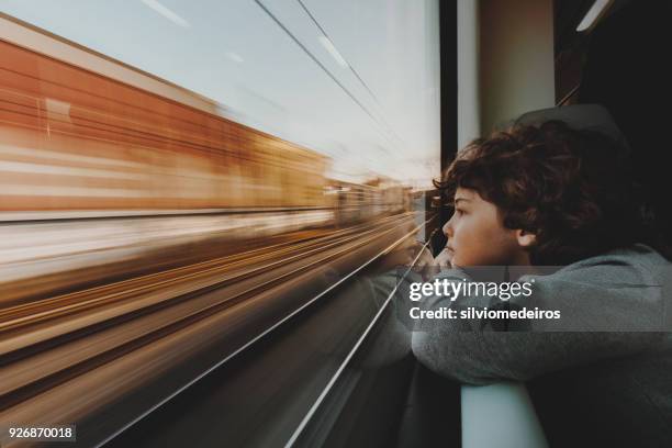 boy looking through train window - slow shutter speed stock-fotos und bilder
