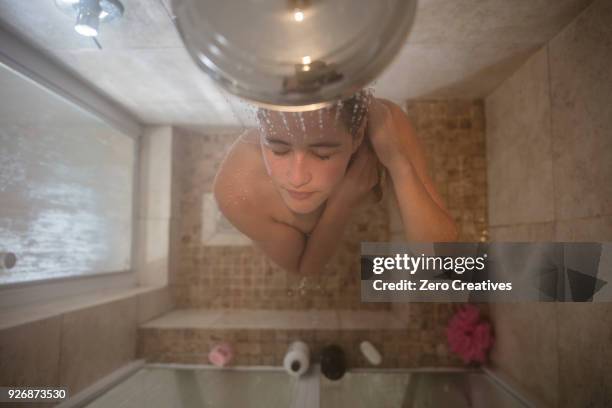 overhead view of young woman in showering - shower head stock pictures, royalty-free photos & images