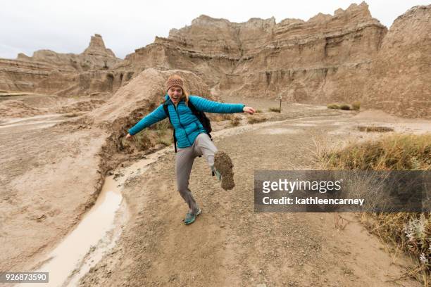 female hiker showing off muddy boots, badlands national park, south dakota, america, usa - badlands national park bildbanksfoton och bilder