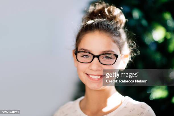 portrait of girl, christmas tree in background - messy bun stockfoto's en -beelden