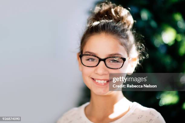 portrait of girl, christmas tree in background - messy hair bun stock pictures, royalty-free photos & images