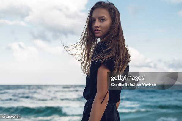 portrait of young woman looking over her shoulder on beach, odessa, odessa oblast, ukraine - over shoulder stock pictures, royalty-free photos & images