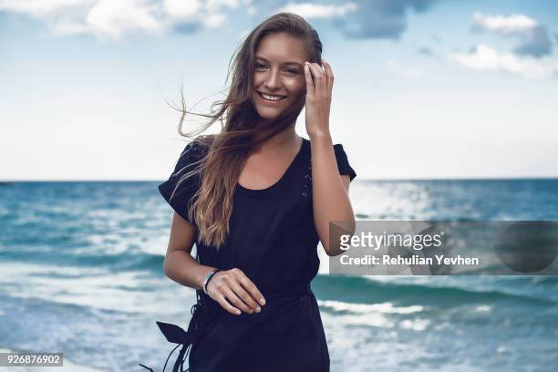 portrait of happy young woman on beach, odessa, odessa oblast, ukraine - 髪に手をやる　女性 ストックフォトと画像