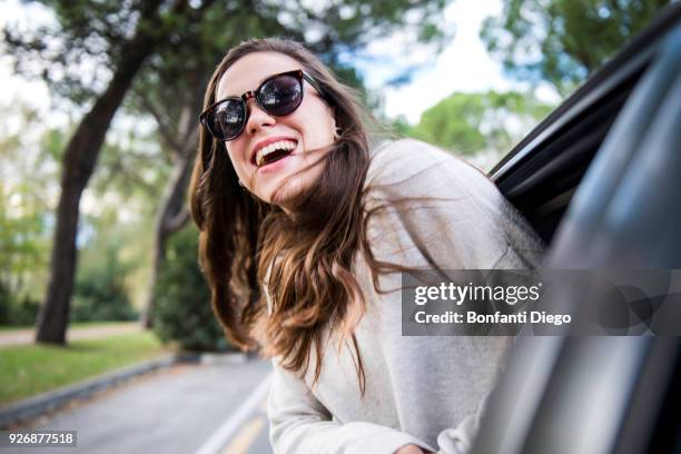 happy young woman on road trip leaning out of car window - vercurago stock pictures, royalty-free photos & images