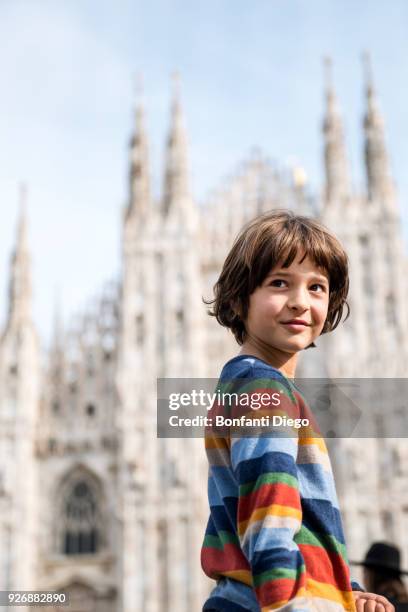 portrait of boy looking over his shoulder in milan cathedral square, milan, lombardy, italy - daily life at duomo square milan stockfoto's en -beelden