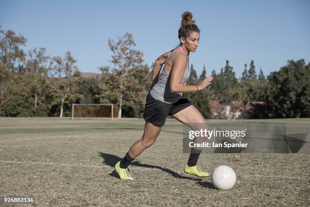 woman on football pitch playing football - dribbling sport fotografías e imágenes de stock
