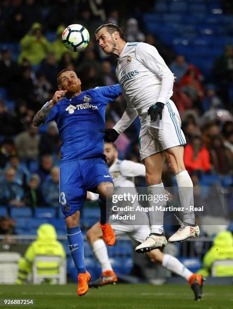 Gareth Bale of Real Madrid competes for the ball with Vitorino Antunes of Getafe during the La Liga match between Real Madrid and Getafe at Estadio...