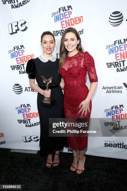 Actors Aubrey Plaza and Elizabeth Olsen pose with the Best First Feature award for 'Ingrid Goes West' in the press room during the 2018 Film...