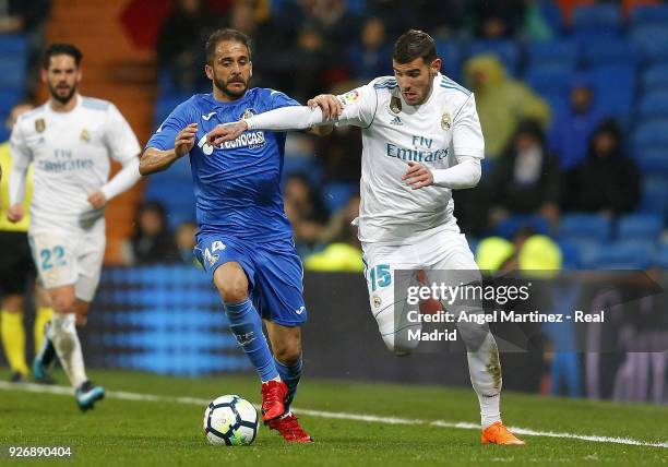 Theo Hernandez of Real Madrid competes for the ball with Sergio Mora of Getafe during the La Liga match between Real Madrid and Getafe at Estadio...