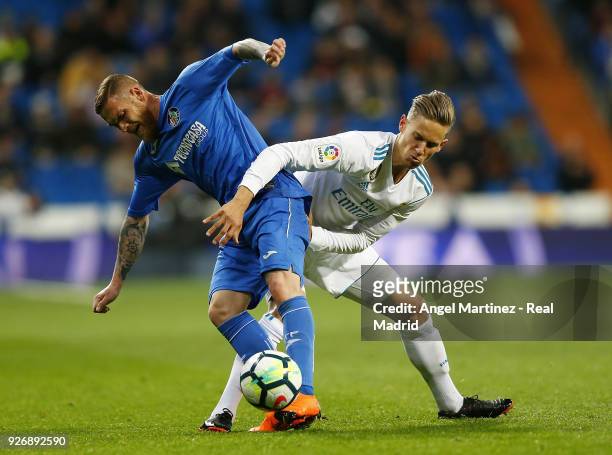 Marcos Llorente of Real Madrid competes for the ball with Vitorino Antunes of Getafe during the La Liga match between Real Madrid and Getafe at...