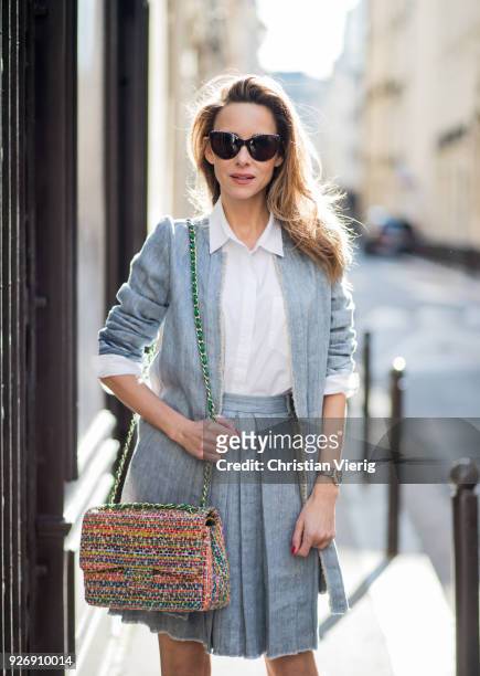 Alexandra Lapp wearing a linen open front blazer with a fringed hem line in a denim optic and a high waist linen pleated skirt in denim optic and a...