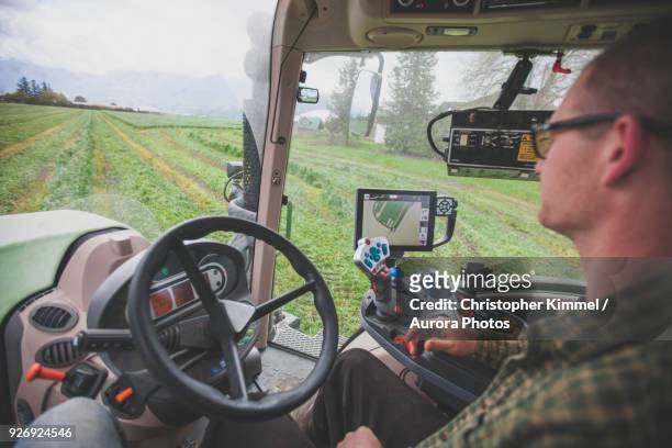 farmer cutting crops with gps controlled tractor, chilliwack, british columbia, canada - agriculteur conducteur tracteur photos et images de collection