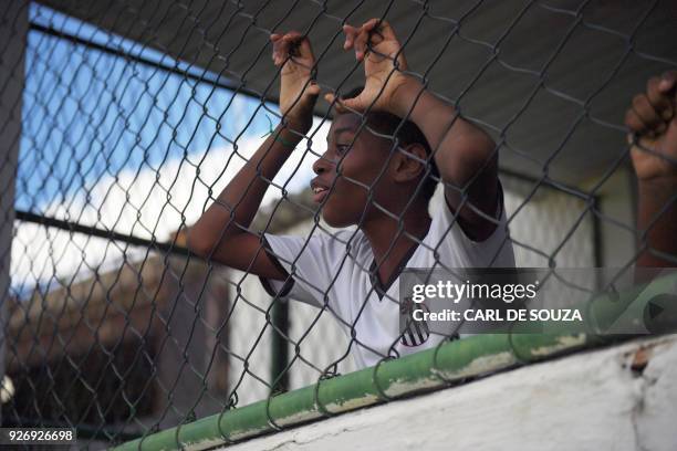 Boy watches his teammates during a trainning session at Sao Cristovao football club, in Rio de Janeiro, Brazil on February 7, 2018. Tiny Sao...