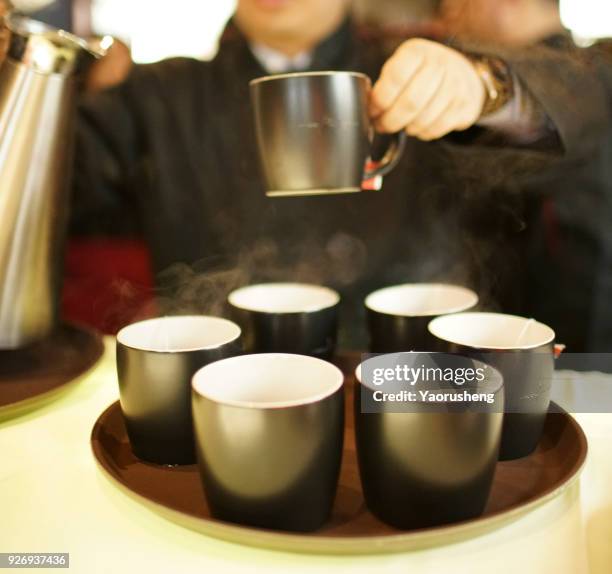 people pouring team into the cup from pot - cezve stockfoto's en -beelden