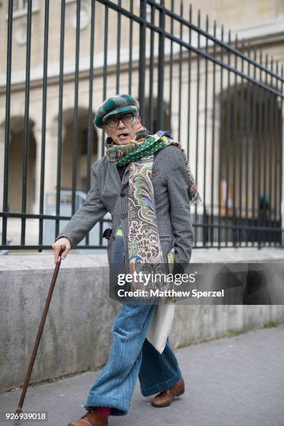 Guest is seen on the street attending Noir Kei Ninomiya during Paris Women's Fashion Week A/W 2018 wearing a grey plaid coat, blue pants, green plaid...