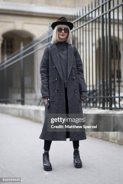 Guest is seen on the street attending Noir Kei Ninomiya during Paris Women's Fashion Week A/W 2018 wearing a grey wool coat and sweater with brown...