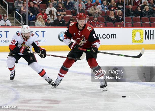 Oliver Ekman-Larsson of the Arizona Coyotes passes the puck away from Tom Pyatt of the Ottawa Senators during the third period at Gila River Arena on...